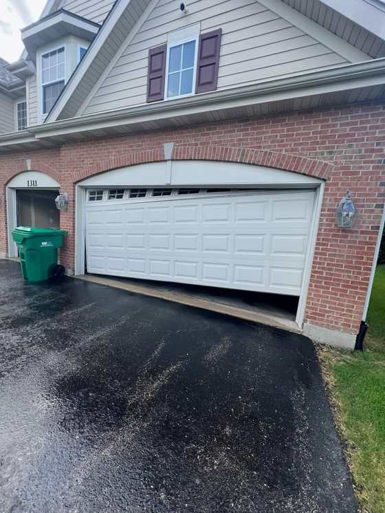 Garage door hanging off its track